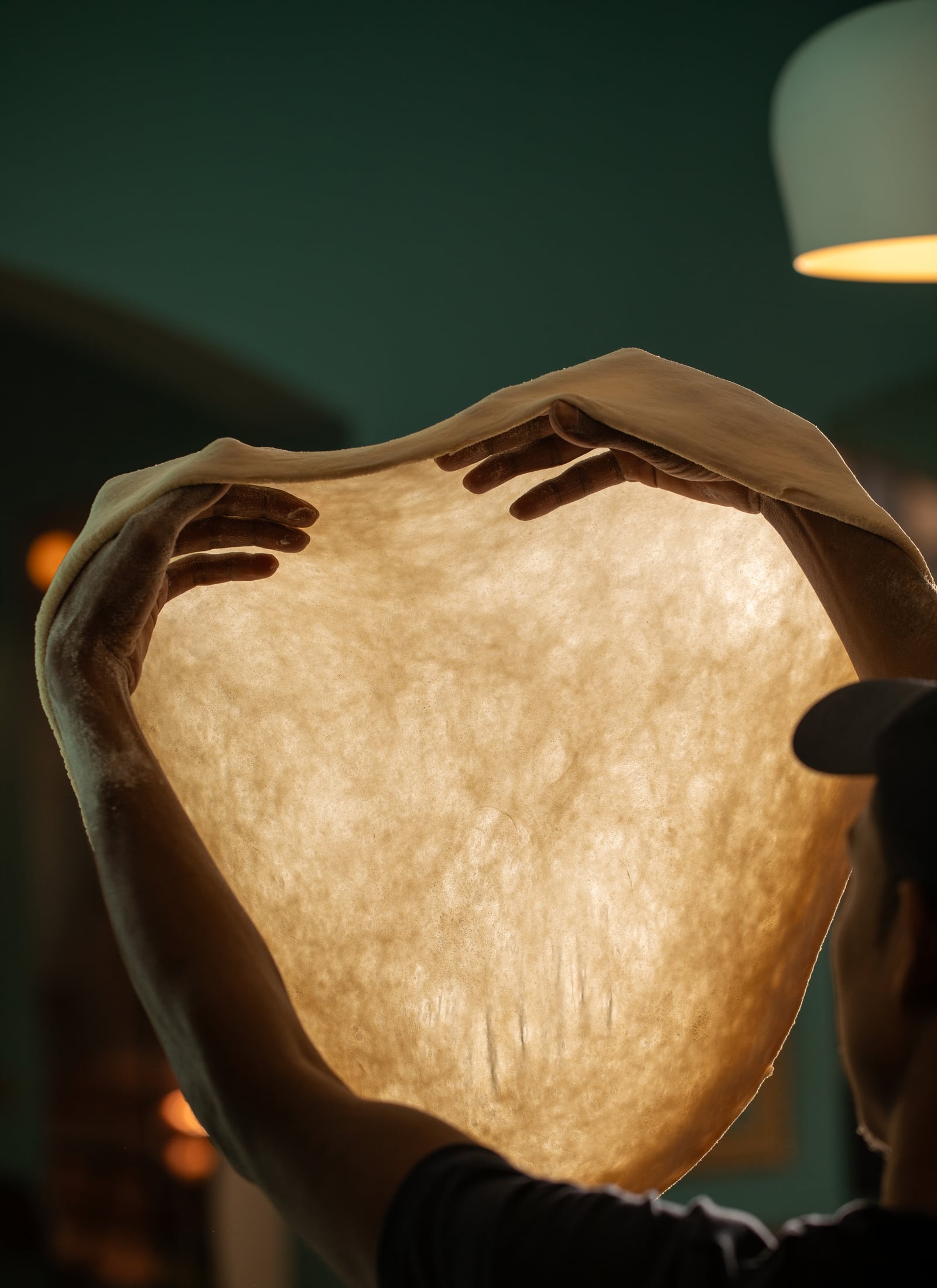 Serious Slice dough being stretched by hand